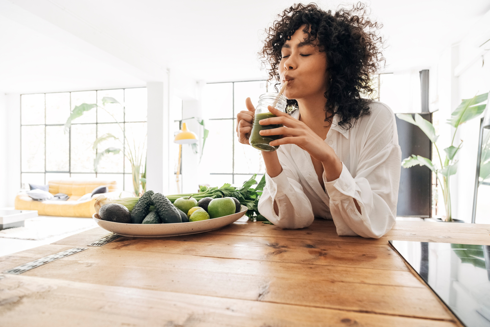 Young,African,American,Woman,Drinking,Green,Juice,With,Reusable,Bamboo