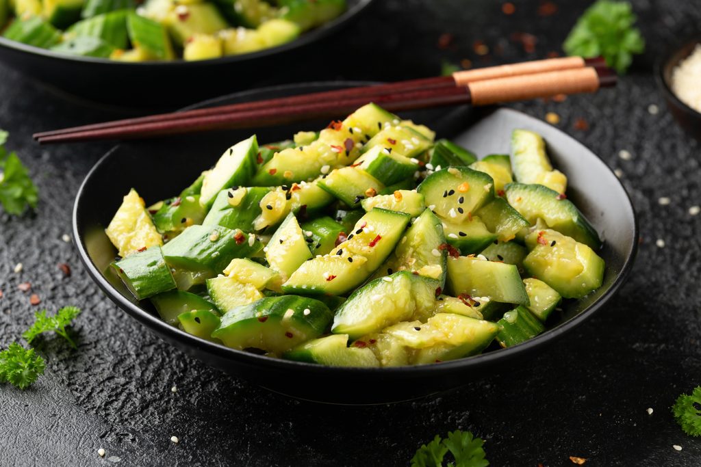 Smashed cucumber spicy Asian style salad with soy sauce dressing, chilli flakes, garlic and sesame seeds